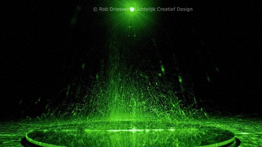 opspattend zand in groen laserlicht